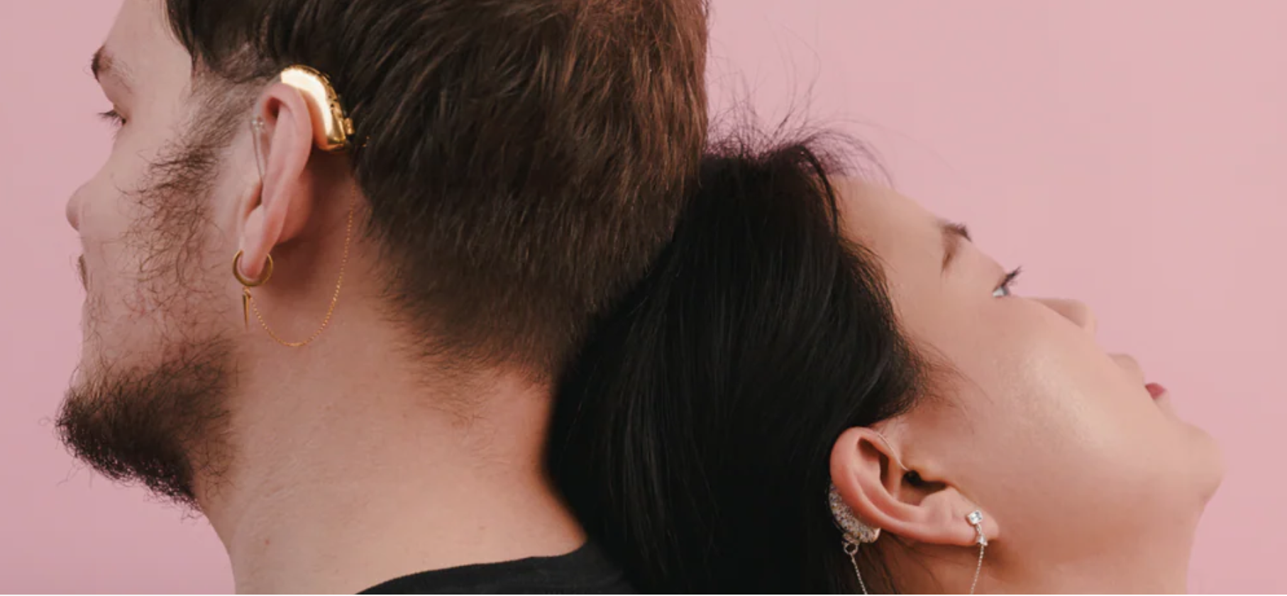 Woman lays her head on man's shoulder and both ear hearing aid covers